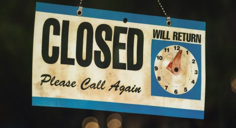 A shop door sign reads 'CLOSED, please call again'. A clock reads 'will return' with the time set for 1.05.
